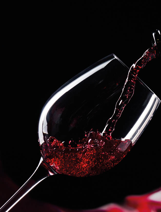 bottle and glass with red wine on a black background