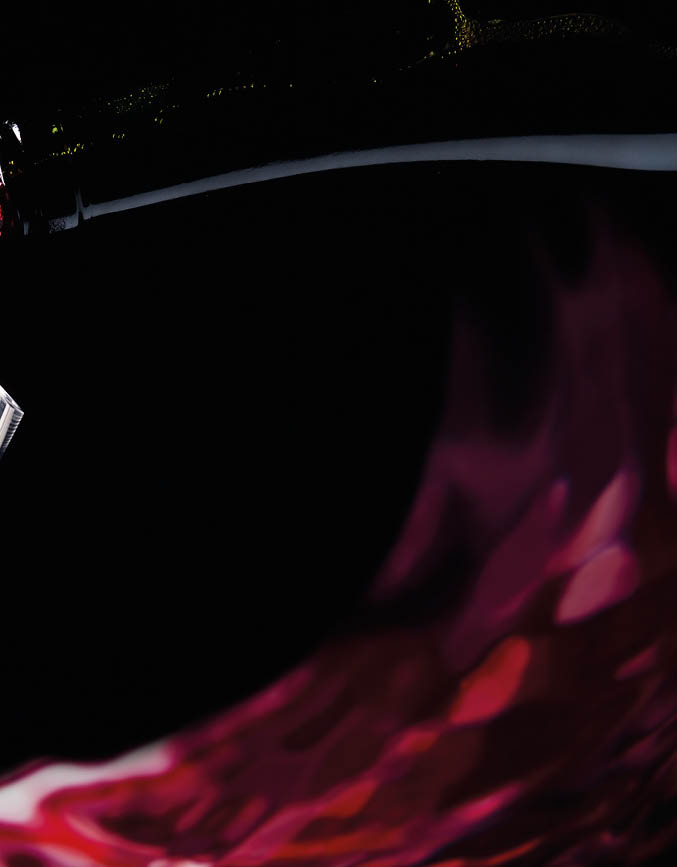 bottle and glass with red wine on a black background