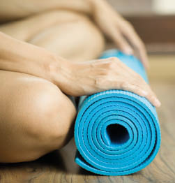 Young woman holding a yoga mat