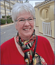 A woman wearing a red shirt and a scarf. Description generated by AI