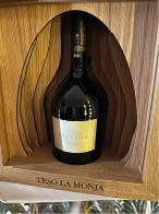 A bottle of wine is in a wooden box. Description generated by AI