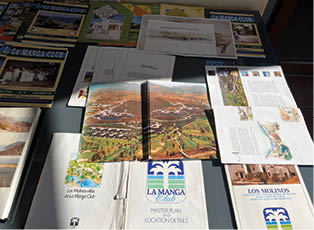 A collection of brochures and pamphlets are laid out on a table. Description generated by AI