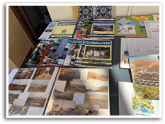 A collection of travel brochures and pamphlets are spread out on a table. Description generated by AI