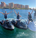 Three people on jet skis in the water. Description generated by AI