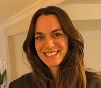 A woman with long hair and a smile on her face. Description generated by AI