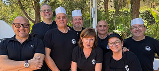 A group of people wearing black shirts and white hats. Description generated by AI