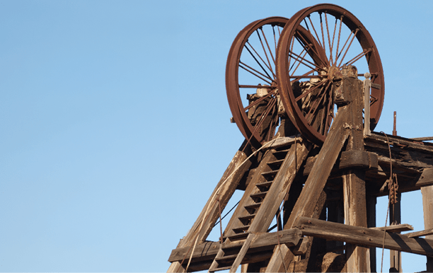 A rusty wheel on a wooden structure. Description generated by AI