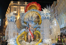 A parade float with a woman in a crown on it. Description generated by AI