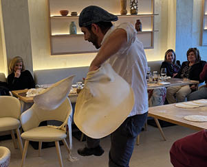 A man is holding a white object in a restaurant. Description generated by AI