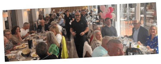 A group of people are sitting at a table in a restaurant. Description generated by AI