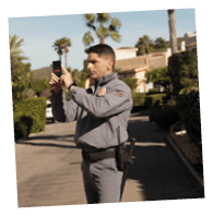 A man in a grey uniform is taking a picture. Description generated by AI