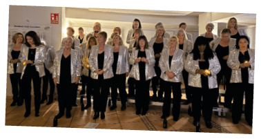 A group of women wearing silver jackets and black pants. Description generated by AI