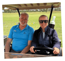 A man and a woman are sitting in a golf cart. Description generated by AI