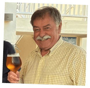 A man holding a glass of beer. Description generated by AI