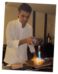 A man is pouring a liquid onto a flame. Description generated by AI