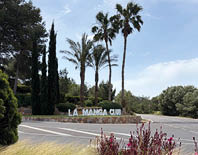 A sign in front of a building that says La Manga Club. Description generated by AI