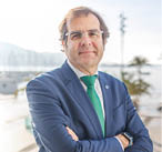 A man wearing a blue suit and a green tie. Description generated by AI
