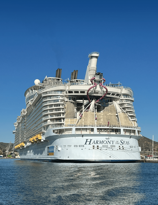 A large cruise ship with a yellow bow. Description generated by AI