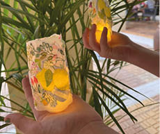 Two hands holding lit candles. Description generated by AI