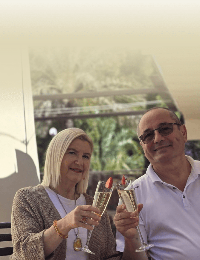 A man and woman holding champagne glasses. Description generated by AI