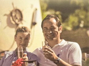 A man and woman are sitting together, holding wine glasses. Description generated by AI