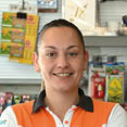 A woman is smiling and holding a card reader at a counter. AI generated content