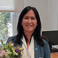 A woman in a blue jacket is holding a bouquet of flowers. AI generated content