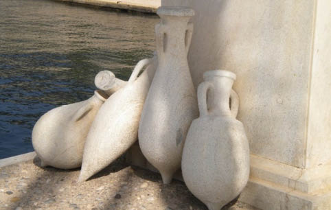 Three white vases on the ground. Description generated by AI