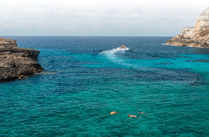 A group of people swimming in the ocean. Description generated by AI