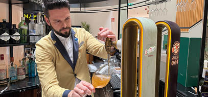 A man pouring a drink into a glass. Description generated by AI