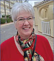 A woman wearing a red shirt and a scarf. Description generated by AI