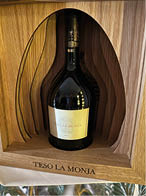 A bottle of wine is in a wooden box. Description generated by AI