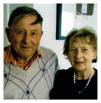 A man and woman are standing together in a black and white photo. Description generated by AI