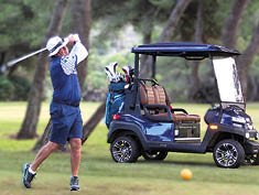 A man is swinging a golf club at a golf ball. Description generated by AI