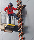 A man is on a ladder on a boat. Description generated by AI