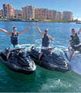 Three people on jet skis in the water. Description generated by AI