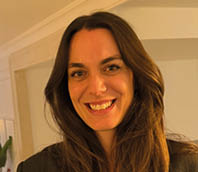 A woman with long hair and a smile on her face. Description generated by AI