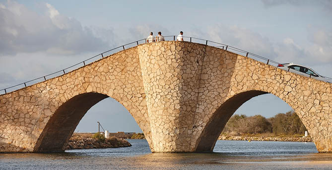 A bridge over water with a car on it. Description generated by AI