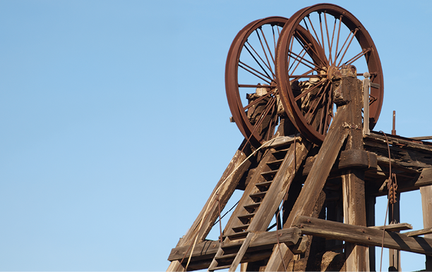 A rusty wheel on a wooden structure. Description generated by AI
