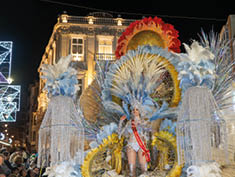 A parade float with a woman in a crown on it. Description generated by AI