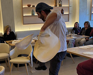 A man is holding a white object in a restaurant. Description generated by AI