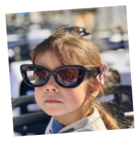 A young girl wearing sunglasses. Description generated by AI