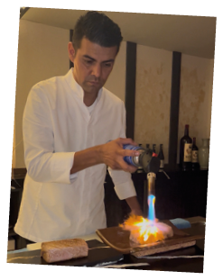 A man is pouring a liquid onto a flame. Description generated by AI