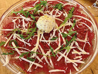 A plate of food with cheese and meat on top. Description generated by AI