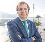 A man wearing a blue suit and a green tie. Description generated by AI