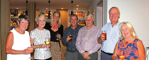 A group of people are standing together, holding wine glasses. Description generated by AI