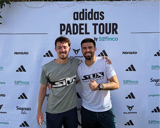 Two men posing in front of a white adidas banner. Description generated by AI