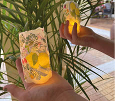 Two hands holding lit candles. Description generated by AI
