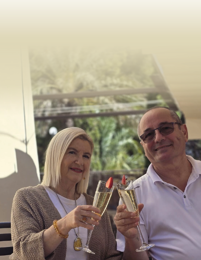 A man and woman holding champagne glasses. Description generated by AI