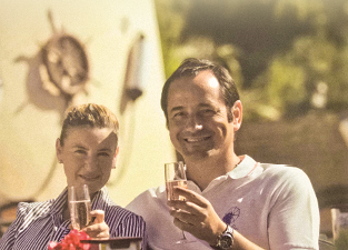 A man and woman are sitting together, holding wine glasses. Description generated by AI